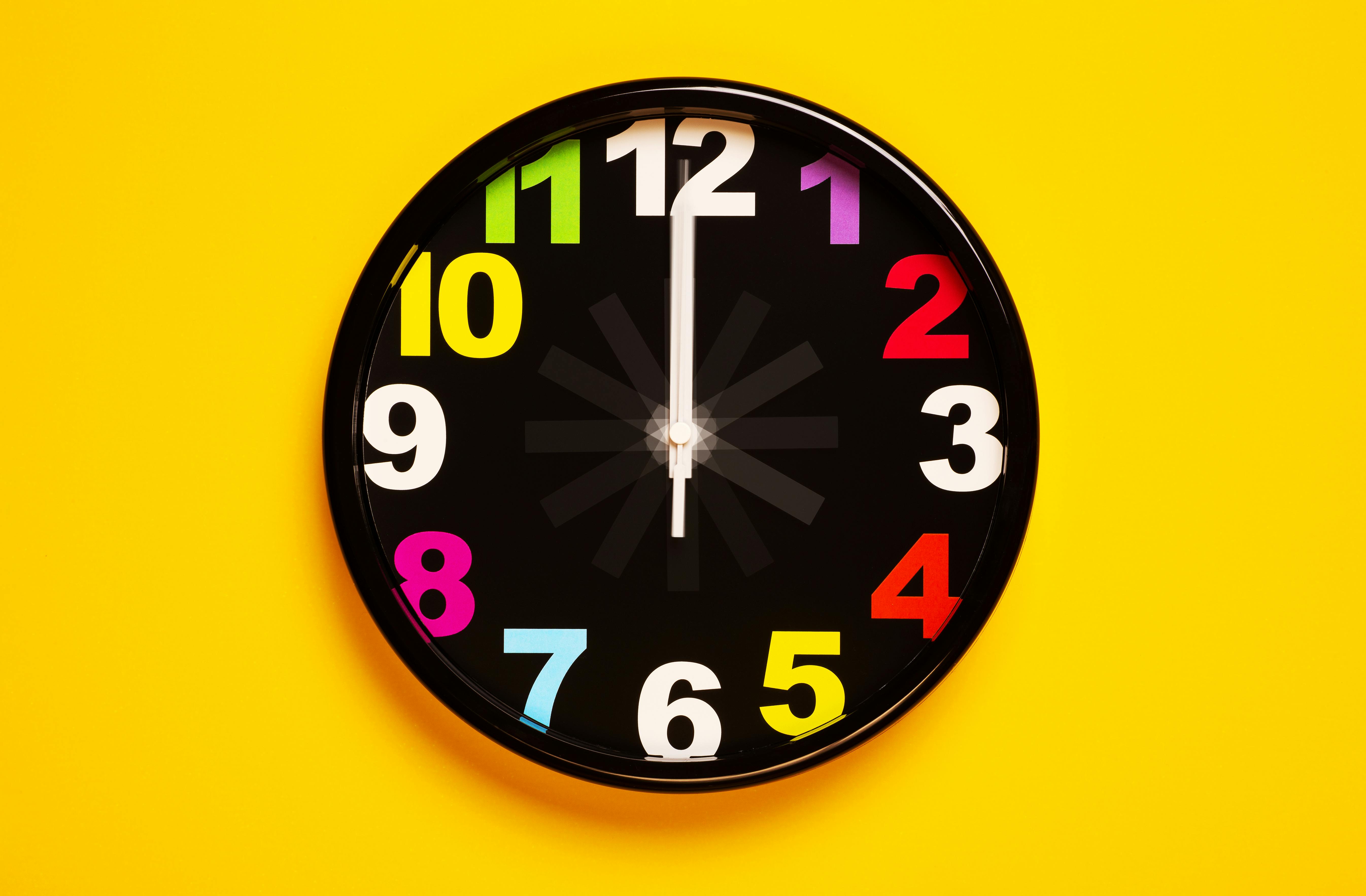 Minimal wall clock hanging on bright wall